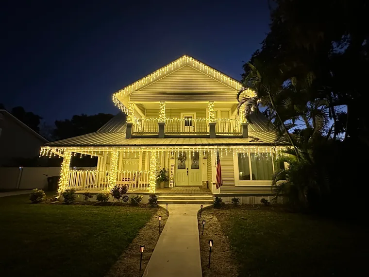 Traditional home with warm white roofline lighting